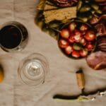 Deska antipasti z czerwonym winem, wędlinami i plastrami kaki