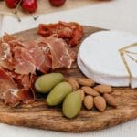 Deska serów z brie, prosciutto, oliwkami i migdałami