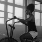 Kobieta ćwiczy na rowerku powietrznym w siłowni