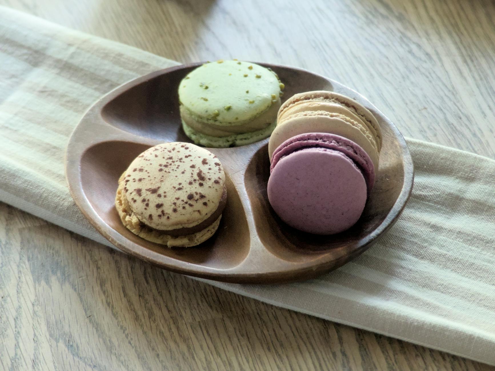 Kolorowe makaroniki na rustykalnym talerzu z drewnianego drewna