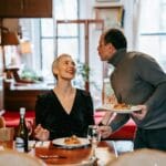 Para przy kolacji z pasta i czerwonym winem w jasnym wnętrzu