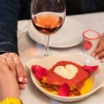 Romantyczna kolacja we dwoje z różowym winem i talerzem w kształcie serca