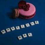 Różnokolorowe francuskie makaroniki ułożone na żywym niebieskim tle