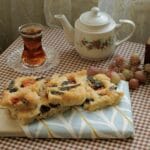 Kawałki focacci z herbatą i winogronami na kraciastym obrusie