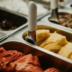 Kolorowe gelato w metalowych pojemnikach w witrynie lodziarni