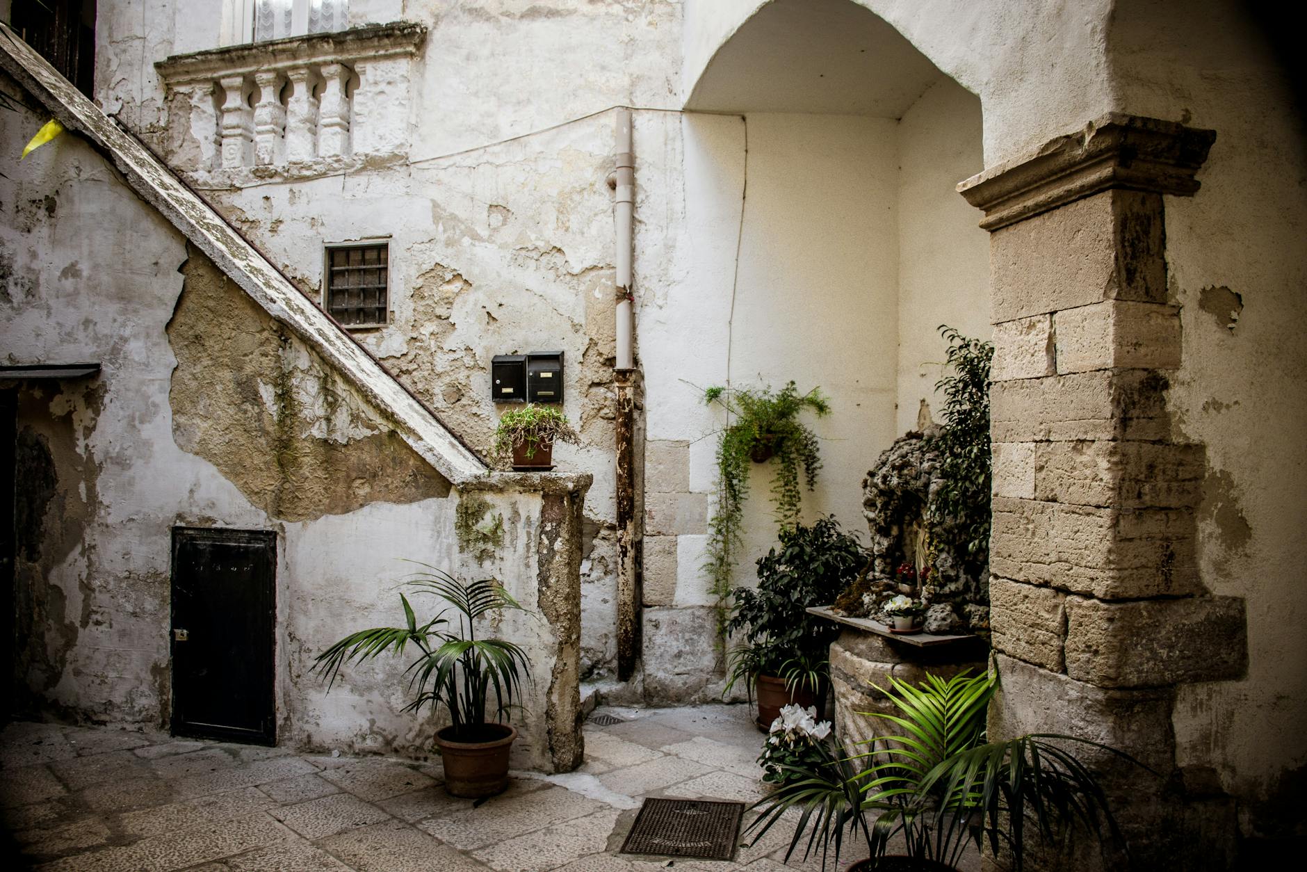 Rustykalny dziedziniec w Apulii z kamiennymi murami i donicami z roślinami