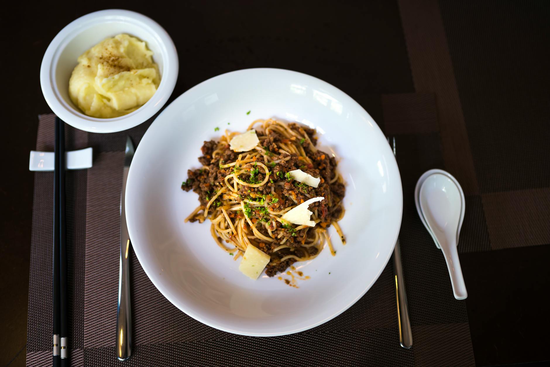 Spaghetti bolońskie z puree ziemniaczanym widziane z góry na stole