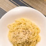 Talerz makaronu cacio e pepe z serem i świeżo mielonym pieprzem