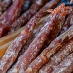 Włoskie salami w laskach ułożone w rzędy, z widoczną strukturą