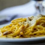 Zbliżenie na talerz spaghetti carbonara posypanego parmezanem