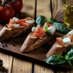 Bruschetta z pomidorami, mozzarellą i bazylią na rustykalnym pieczywie