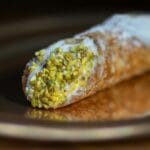 Cannolo z kremem i pistacjami w zbliżeniu, widoczna chrupiąca skórka