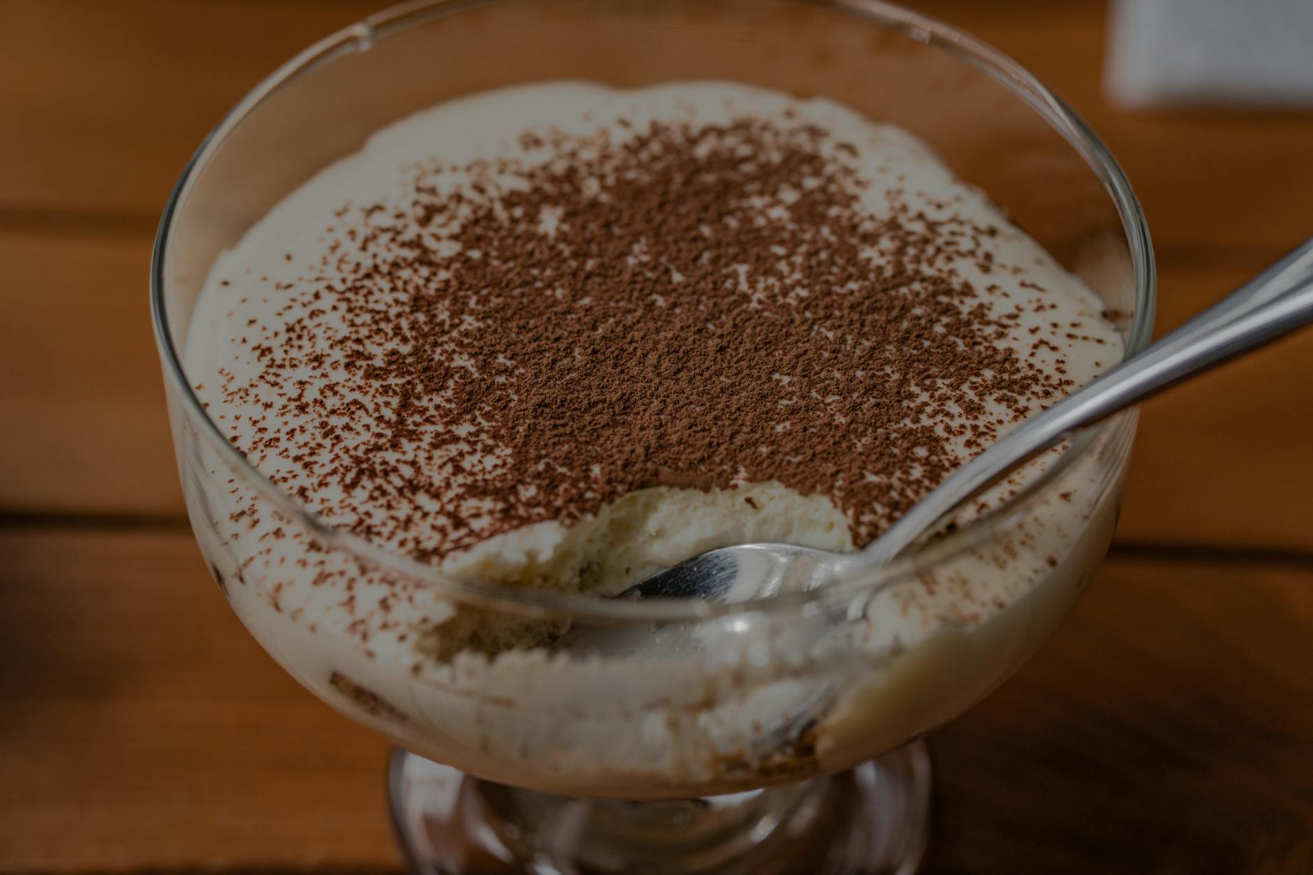 Kremowe tiramisu w szklanym pucharku posypane kakao