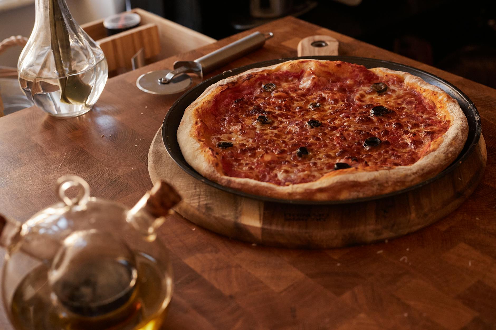 Pizza Margherita w domu: ciasto, fermentacja i pieczenie na kamieniu Pizza Margherita prosto z pieca na drewnianym stole z akcesoriami kuchennymi