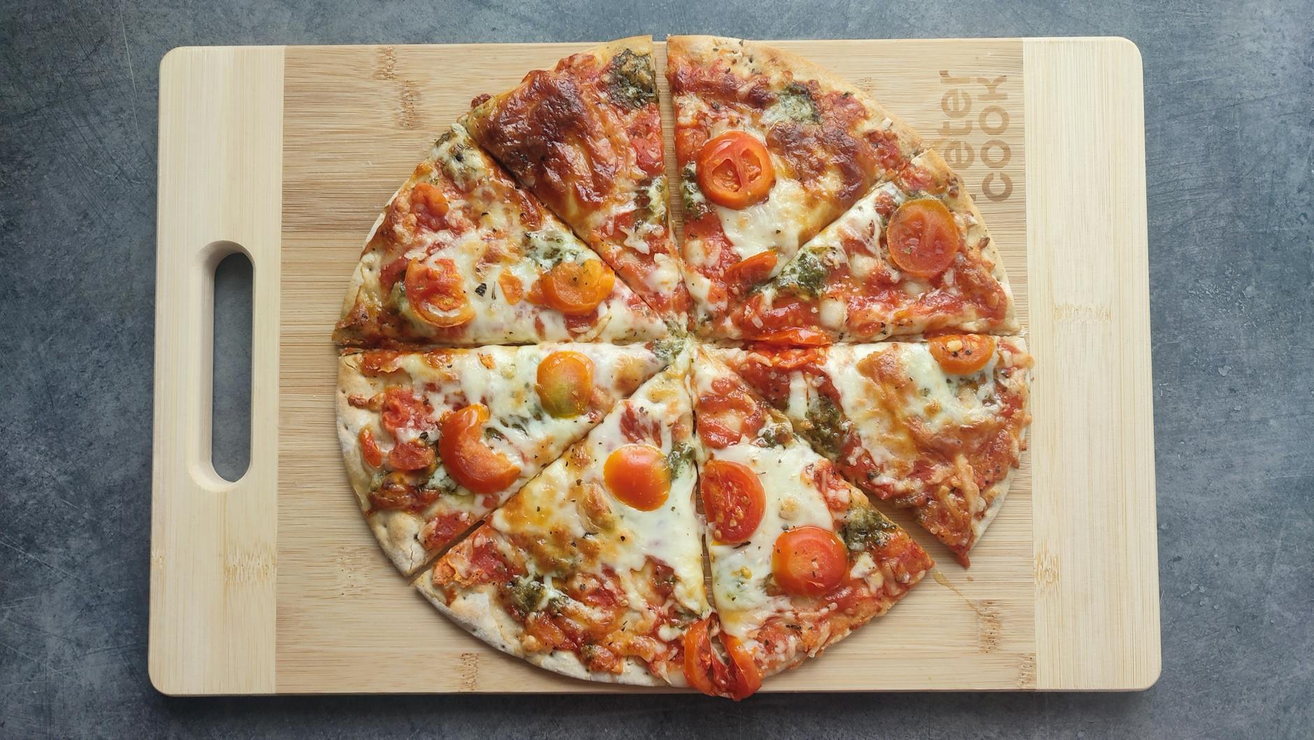 Pizza Margherita z pomidorami i bazylią na drewnianej desce