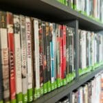 Półka biblioteczna z kolorowymi pudełkami filmów i seriali DVD