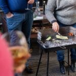 Wino do włoskiego grilla: co pić do salsiccii, warzyw i ryb z rusztu Przyjaciele przy grillu piją wino i pieką warzywa oraz kiełbaski