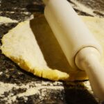 Rozwałkowywanie ciasta na pizzę na oprószonym mąką blacie