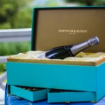 Elegancki kosz prezentowy z włoskim winem na stole w ogrodzie