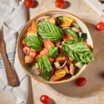 Kolorowa sałatka panzanella z pomidorami i bazylią na stole